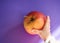 Hand of a baby grabbing an apple from a table