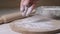 Hand of baker kneading dough for pizza preparation. Chef cook making dough for baking cake on wooden table. Process