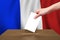 Hand with ballot and wooden box on Flag of France