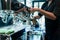 Hand of a barista holding a stainless mug while using a modern c