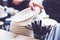 Hand of bartender with saucers and plastic straws