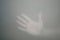 Hand behind the frosted glass. hand silhouette in the mist. loneliness concept. palm touches the glass window