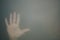 Hand behind the frosted glass. hand silhouette in the mist. loneliness concept. palm touches the glass window