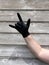 Hand with black rubber protect glove gesturing rock, rocker, goat, roxanne