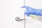 a hand in a blue disposable rubber glove sprinkles with an alcohol disinfectant a door handle,