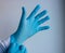 Hand in a blue glove on a white background