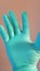 A hand in a blue latex glove