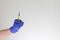 Hand in blue medical glove holding syringe. Medicine, quarantine and COVID-19 coronavirus pandemic concept. Copy space.