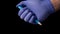 Hand in blue medical protective gloves uses a ballpoint pen by pressing a button.