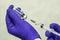 A hand in a blue medical surgical glove picks up a vaccine from an ampoule with the syringe vial inscription COVID19 vaccine