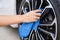 Hand with blue microfiber cloth cleaning car