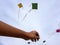Hand of a boy raises a kite in a sky