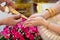 Hand of a bride receiving holy water from elders