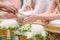 Hand of a bride receiving holy water from elders in thai culture