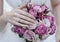 Hand of the bride with a ring holds a wedding bouquet. Wedding decorations. Close-up. The bride`s bouquet