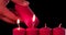 Hand burning Christmas candle on dark