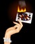 Hand with a burning playing card