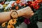 hand business woman wearing wooden watch with copy space and beautiful flowers background. image for