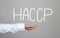 Hand of businessman and hand drawn text HACCP system.