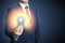 Hand of businessman holding illuminated light bulb, idea, innovation and inspiration concept. Bright idea in hand businessman.