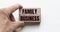 Hand of a businessman holding wooden blocks. Conceptual image. Text FAMILY BUSINESS concept business succeed