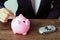 Hand of businessman insert coin into piggy bank with small car m