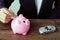 Hand of businessman insert coin into piggy bank with small car m