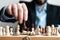 Hand of businessman moving chess figure in competition success play. strategy, management or leadership concept.