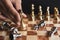 Hand of businessman moving golden chess figure for eliminating in battle competition with last successful ending game. Leadership