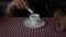 Hand of businessman stirring espresso coffee in cafe