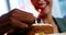 Hand of businesswoman lighting candles on cake with colleague