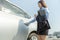 Hand of  businesswoman opening a car door and left hand hold cup of coffee and tablet