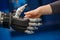 Hand of a businesswoman shaking hands with a Android robot