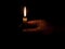 Hand with candle in darkness