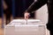 Hand casting a vote into the ballot box