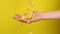 Hand catches cornflakes on yellow background