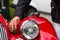 Hand of a caucasian man holding a cloth and cleaning or drying the wheel arch and headlamp of a classic car after rain