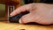 Hand of a Caucasian man working with the mouse on a wooden table, remote work, freelancer, workplace.