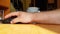 Hand of a Caucasian man working with the mouse on a wooden table, remote work, freelancer, workplace