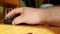 Hand of a Caucasian man working with the mouse on a wooden table, remote work, freelancer, workplace