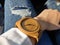 hand of caucasian women wearing wood watch with jean pants background