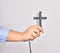 Hand of caucasian young catholic woman holding christian cross over isolated white background