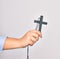 Hand of caucasian young catholic woman holding christian cross over isolated white background