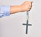 Hand of caucasian young catholic woman holding christian cross over isolated white background