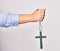 Hand of caucasian young catholic woman holding christian cross over isolated white background