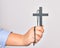 Hand of caucasian young catholic woman holding christian cross over isolated white background