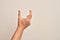 Hand of caucasian young man showing fingers over isolated white background picking and taking invisible thing, holding object with