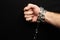 Hand chained on a black background, silver metal chain