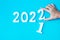 Hand change 2021 to 2022 number on blue background. Plan, finance, Resolution, strategy, solution, goal, business and New Year