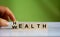 Hand changes the word `Health` to `Wealth